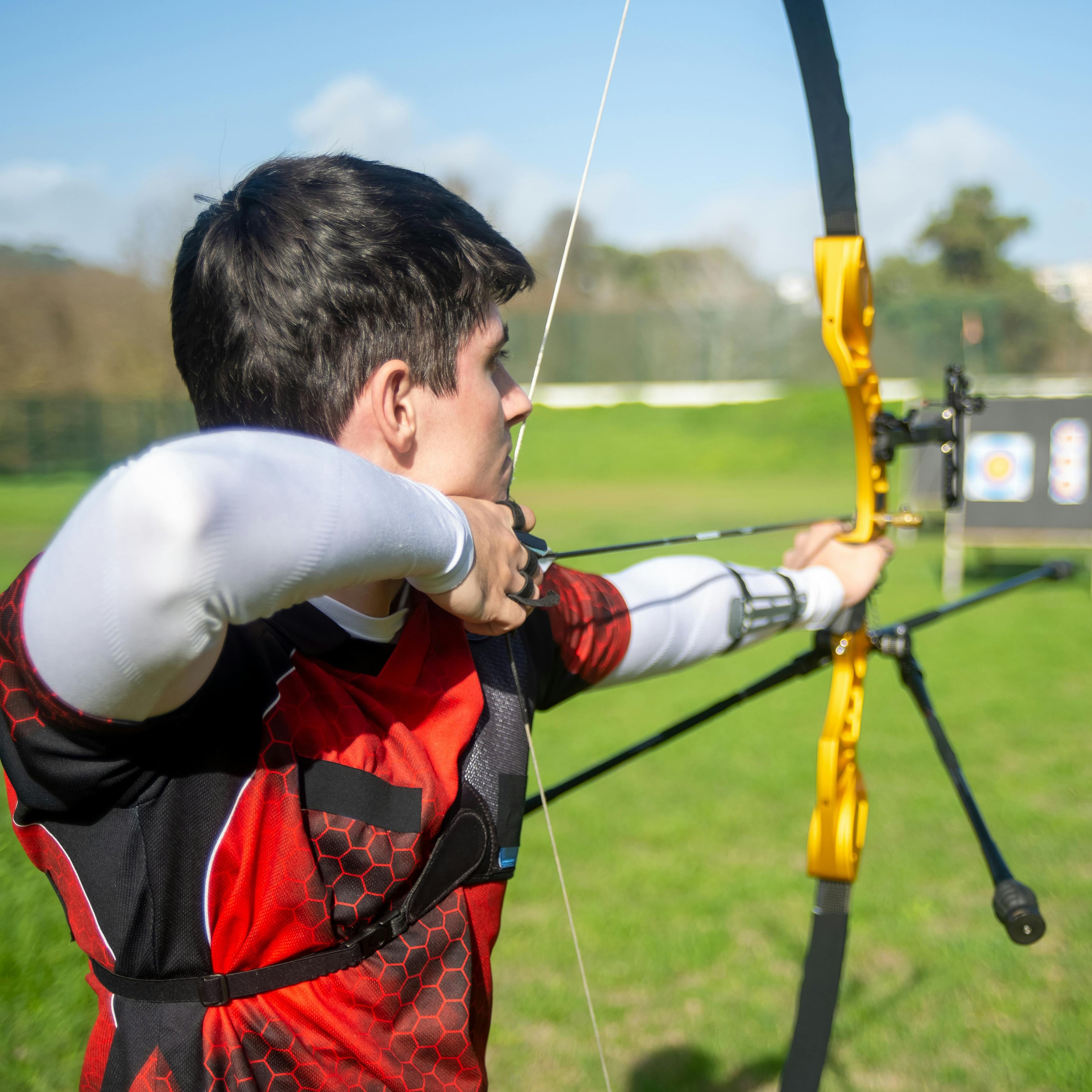 Archer aiming at targets on a sunny outdoor club range