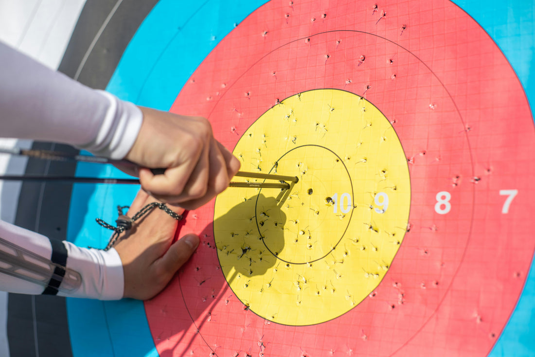 Archer retrieving arrows from a target at an outdoor archery range