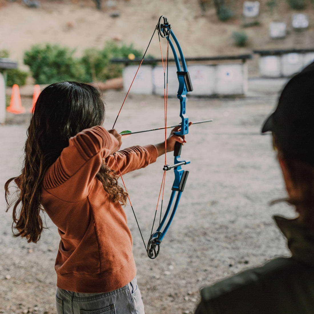 Young archer practicing outdoors with an affordable recurve bow