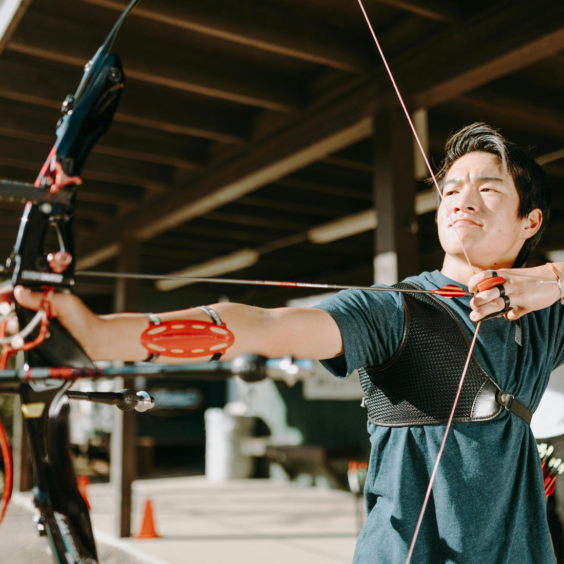 Archer aiming a recurve bow on an outdoor range