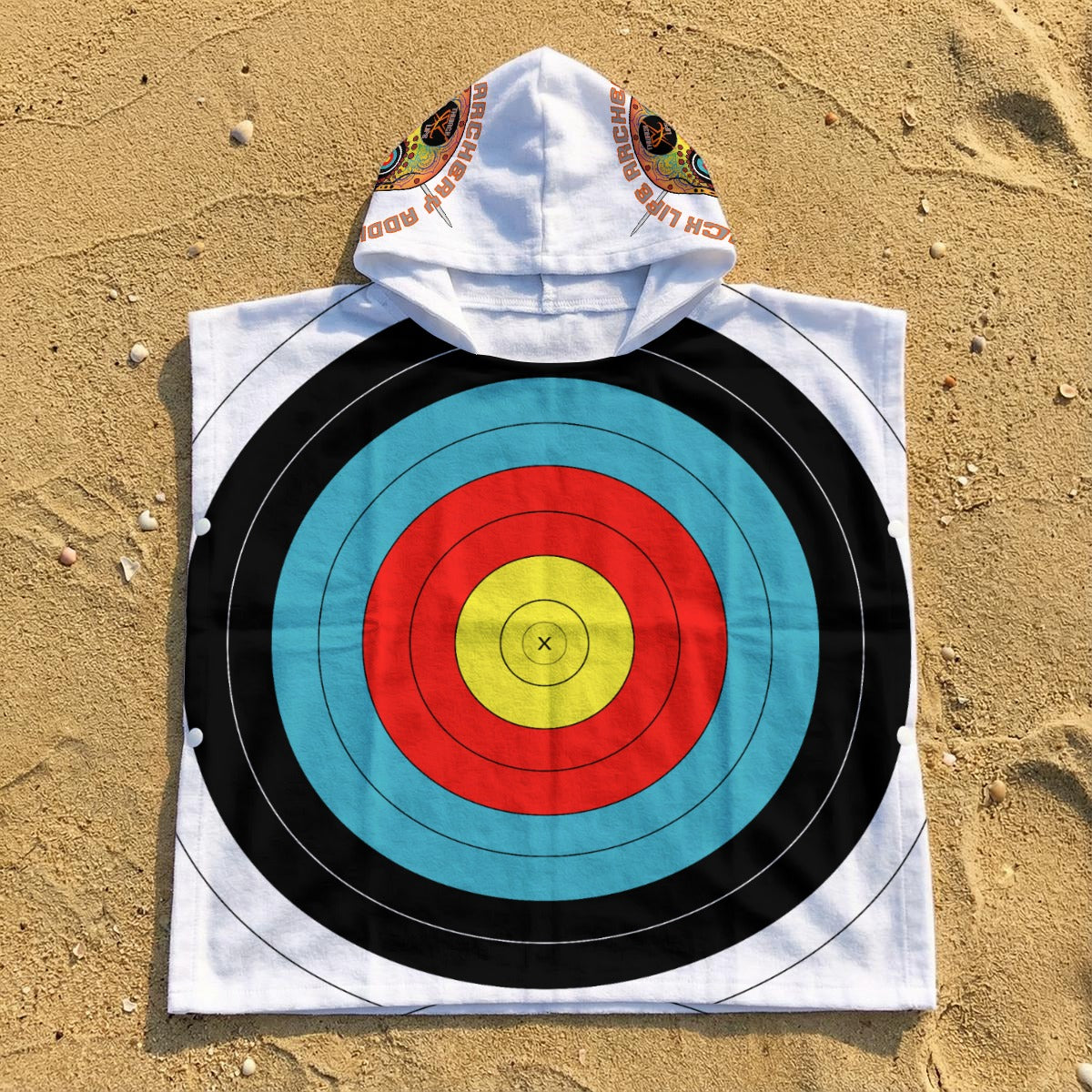 TLAA Target Kids' Towel Poncho laid flat on sand, showing the 10-ring target print, hood and side snaps