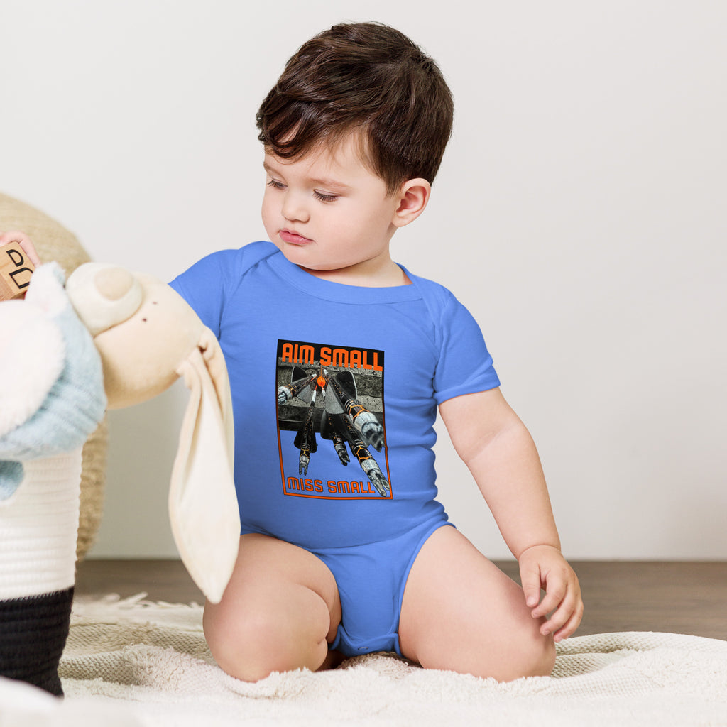 Aim Small Miss Small Baby Onesie in Heather Columbia Blue, worn by a baby sitting with a plush toy