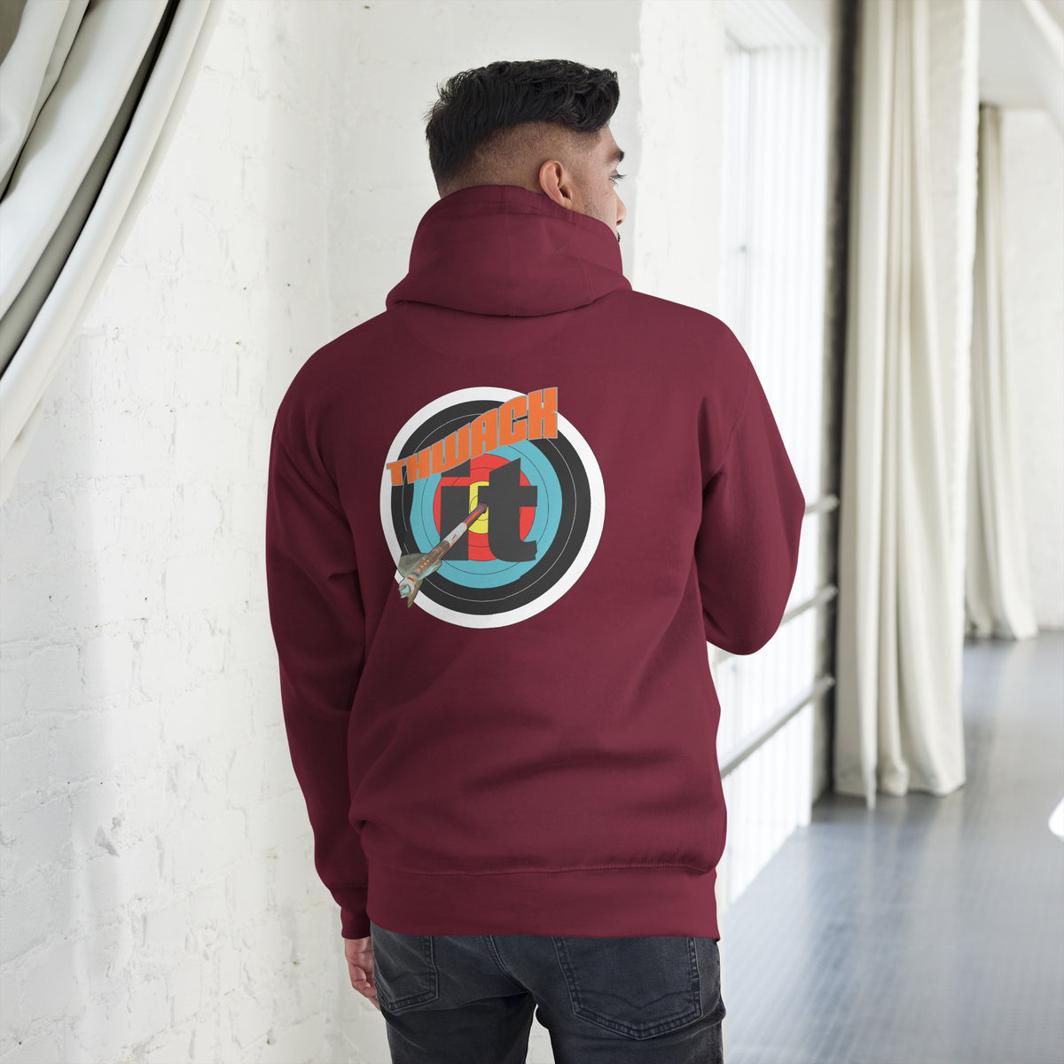 Thwack It Pullover Hoodie in Maroon, back view on a model showing the THWACK it target-and-arrow design